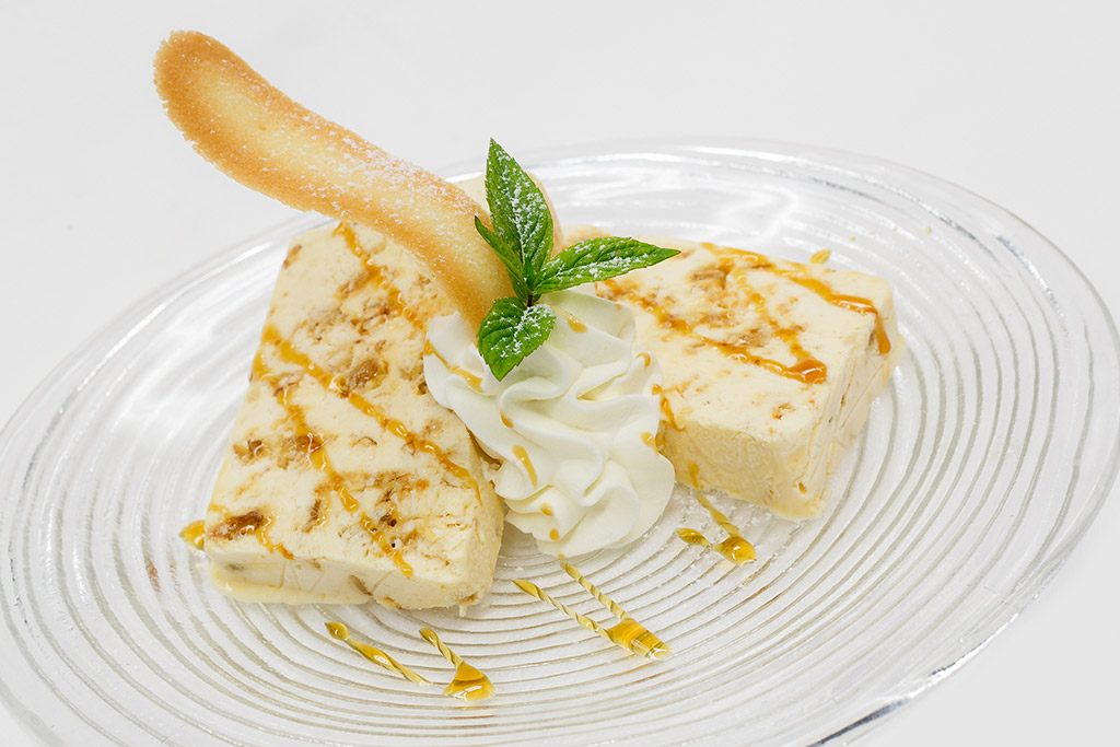 Semifreddo al caramello con panna montata, biscotto e menta